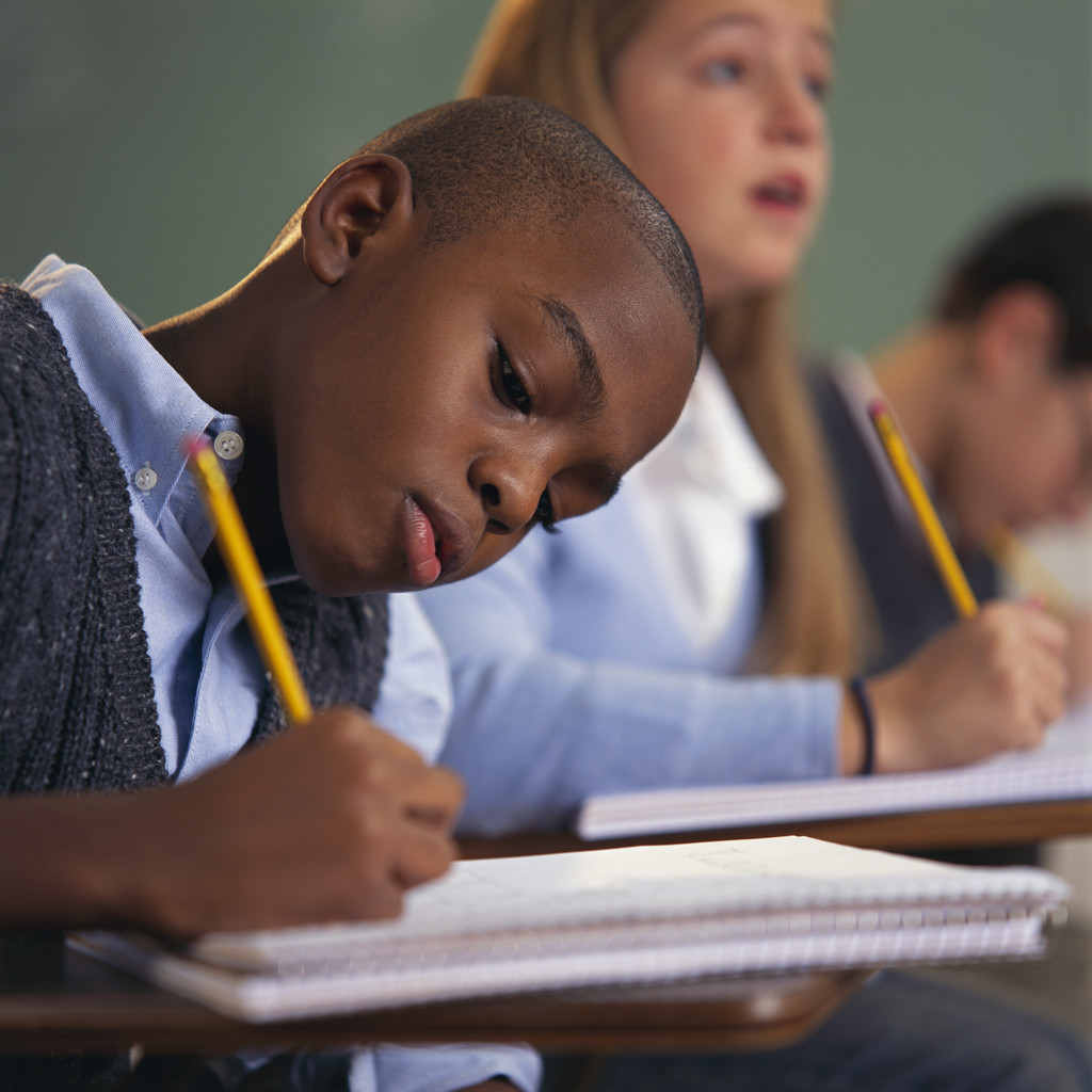 Schoolboy Writing in Notebook